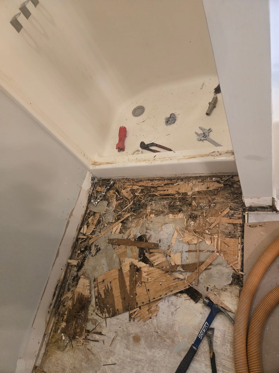 The shower area with the old stall removed and the floor torn up