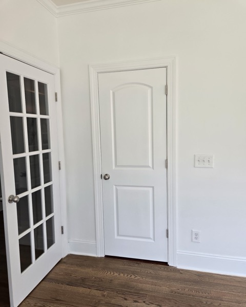 The same room after the conversion, a finished bedroom with a framed wall, door and custom closet