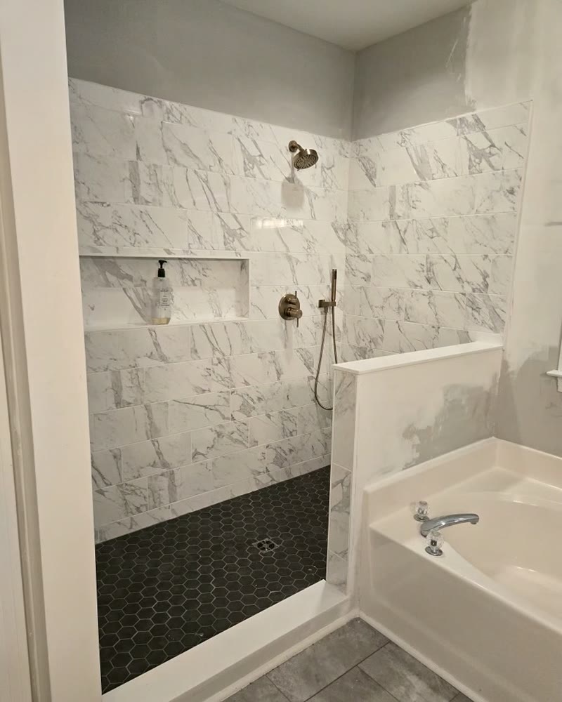 Marble-look tile set to the ceiling with the cut-in niche finished